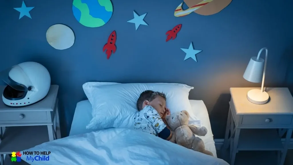 A young boy sleeps peacefully in a space-themed bedroom, cuddling a soft teddy bear. The dim lighting, cozy bedding, and calming decor create a sleep-friendly environment tailored to his sensory needs. A nightlight on the bedside table provides gentle illumination, supporting a structured bedtime routine for kids with autism and ADHD. The "How to Help My Child" logo is visible in the corner.
