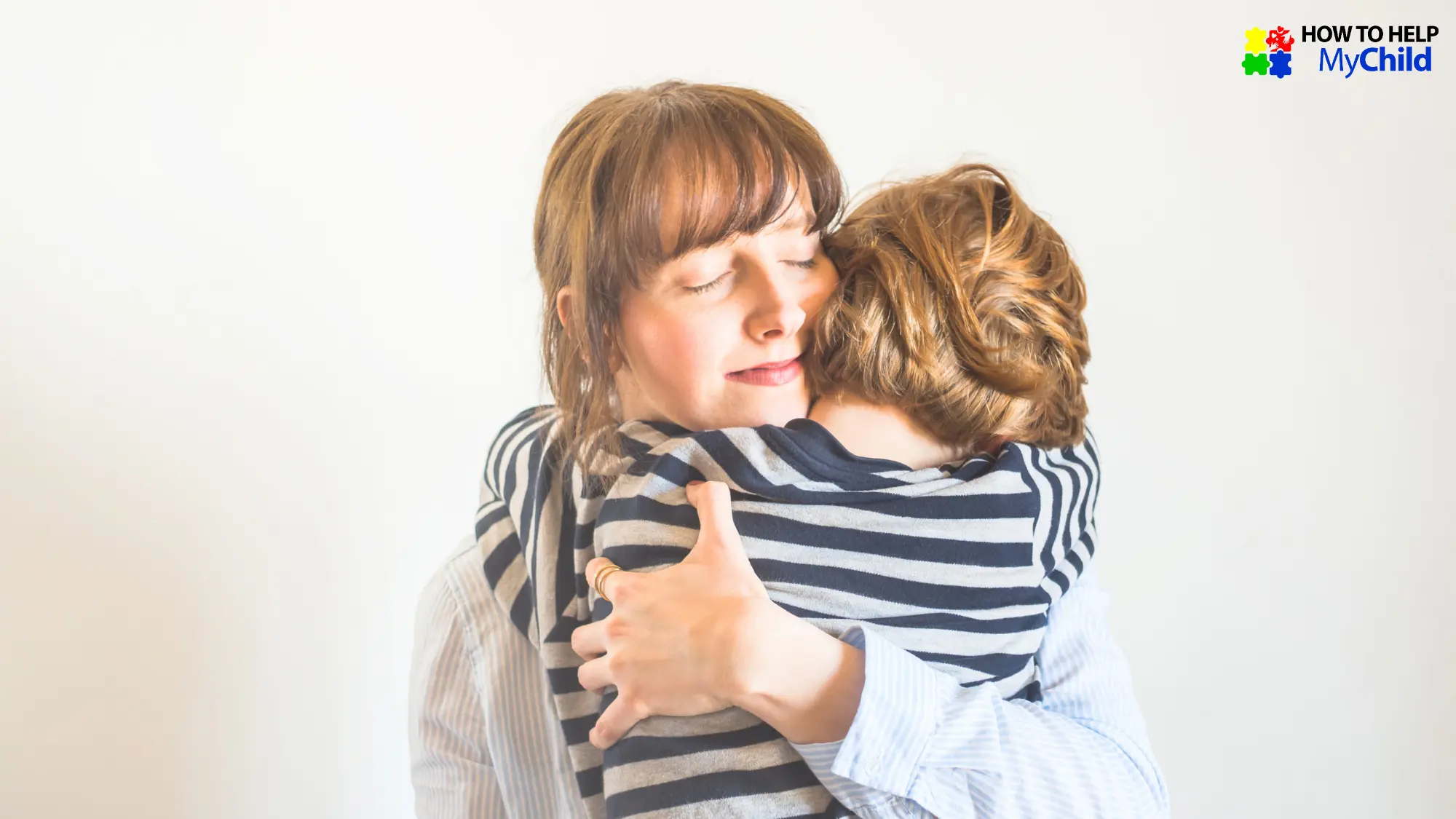 Mother gently hugging her neurodivergent child during a quiet moment, both wearing striped shirts. The mom’s eyes are closed, offering calm support and emotional connection. This image represents how to manage meltdowns in children with autism or ADHD using comfort, regulation, and presence