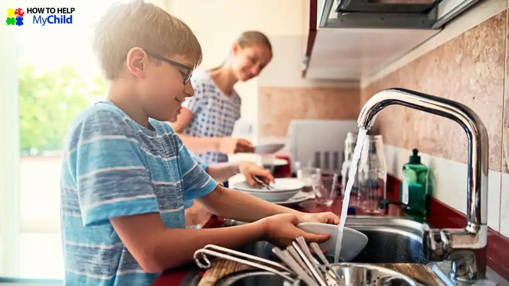 Boy with ADHD smiling while washing dishes alongside his mom—demonstrating effective chores for kids with autism and ADHD, taught by How to Help My Child.